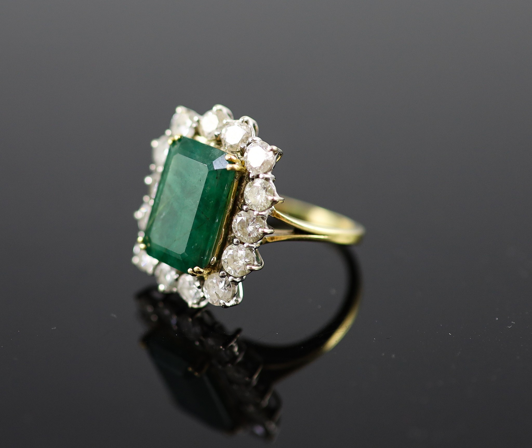 A mid to late 20th century 18ct gold, emerald and diamond set shaped rectangular cluster ring